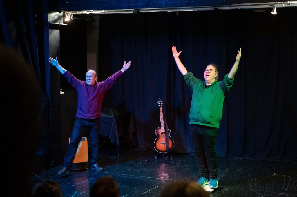 Kuvassa näyttelijät kädet ylhäällä.