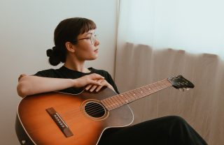 Kuvassa Reetta Karhunen kitara sylissään.